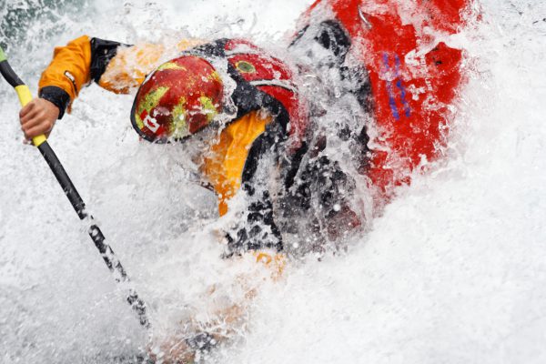 Andrew Jobe dives into a hole in a whitewater kayak on the Kananaskis River, Kananaskis County, Alberta, Canada